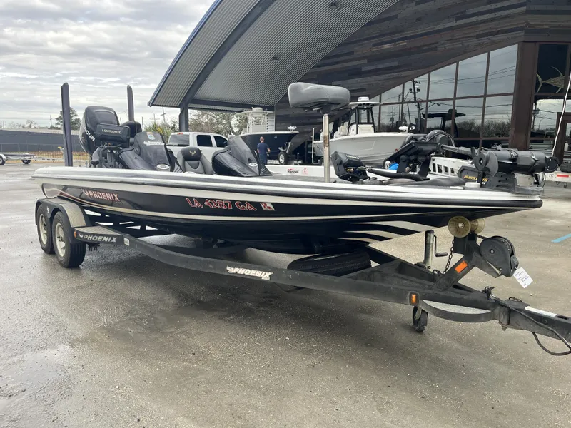 Slide: The Image of 2012 Phoenix 921 PRO XP boat on trailer, parked outside a modern building. - 2