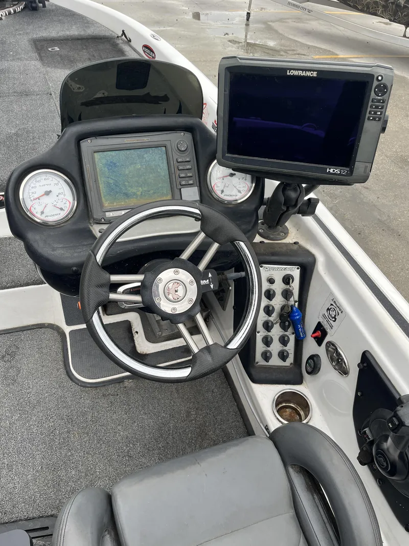 Slide: The Image of 2012 Phoenix 921 PRO XP boat dashboard with steering wheel and navigation equipment. - 8