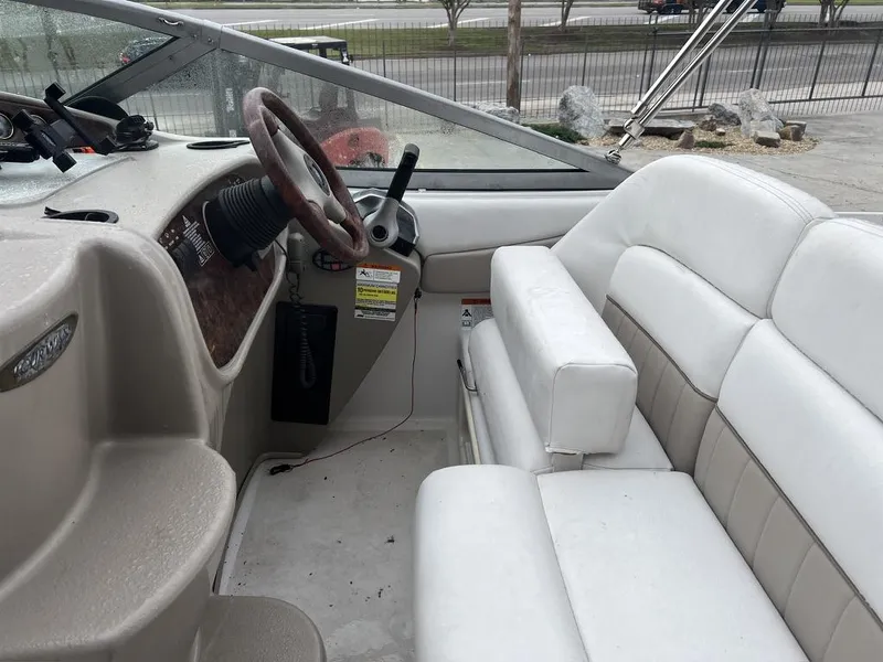 Slide: The Image of 2004 Four Winns 248 Vista boat interior with steering wheel and white seating. - 10
