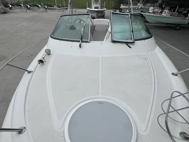 Slide: The Image of 2004 Four Winns 248 Vista boat deck with windshield and railing in a marina. - 13
