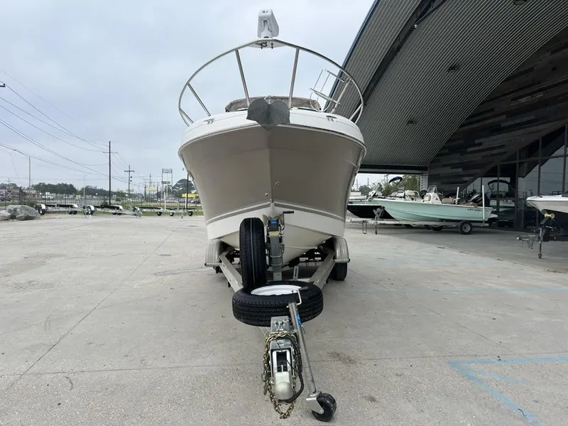 Slide: The Image of 2004 Four Winns 248 Vista boat on trailer, parked outside a modern building. - 3