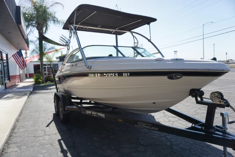 Slide: The Image of 2006 Chaparral SSi 190 boat on trailer, parked outdoors with canopy. - 11