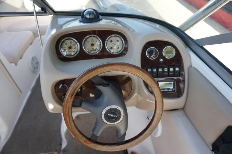Slide: The Image of 2006 Chaparral SSi 190 boat dashboard with wooden steering wheel and gauges. - 13