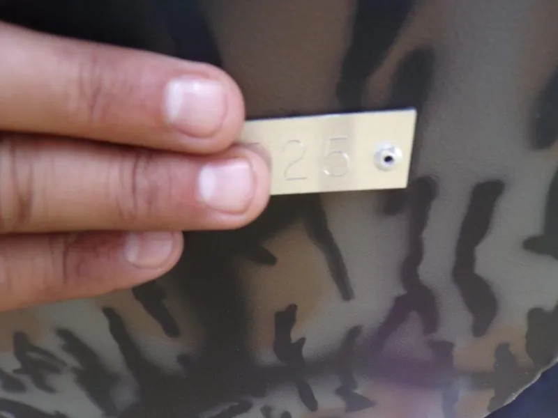 Slide: The Image of Hand holding a metal tag with "25" on Xpress H20BAY 2025 model. - 20