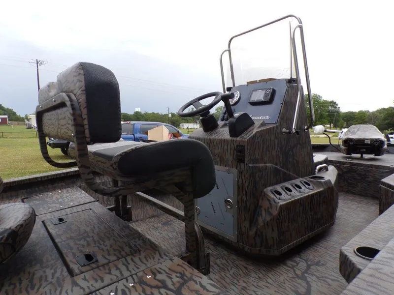 Slide: The Image of 2025 Xpress H20BAY boat interior with steering console and seating, featuring a camo design. - 5