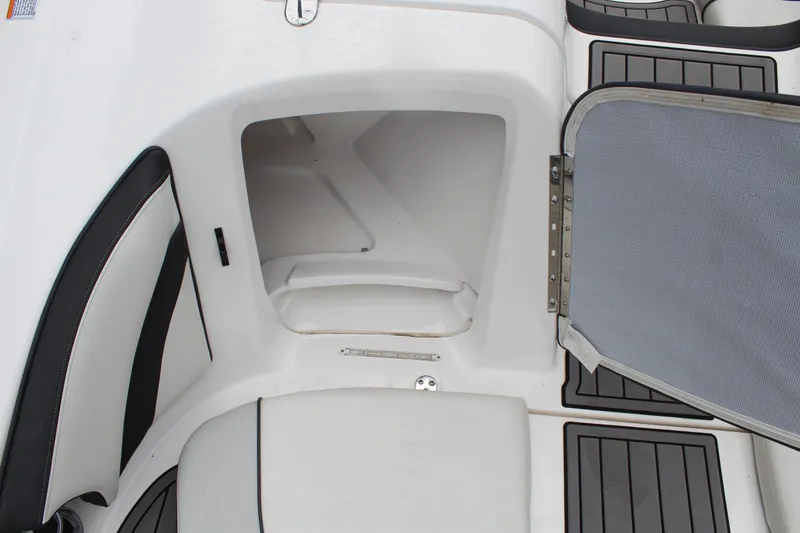 Slide: The Image of 2019 Yamaha Boats 242 Limited S storage compartment with open hatch and seating area. - 15