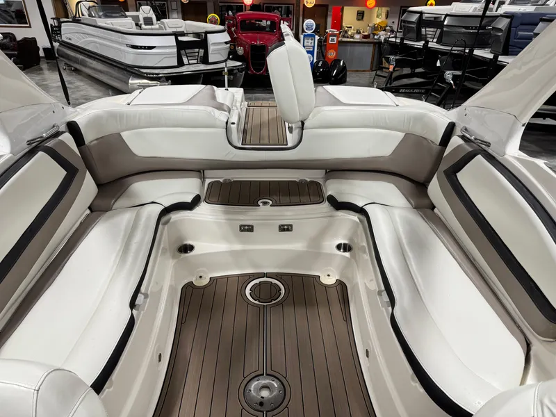 Slide: The Image of 2012 Larson LXi 288 boat interior with white seating and wood flooring. - 13