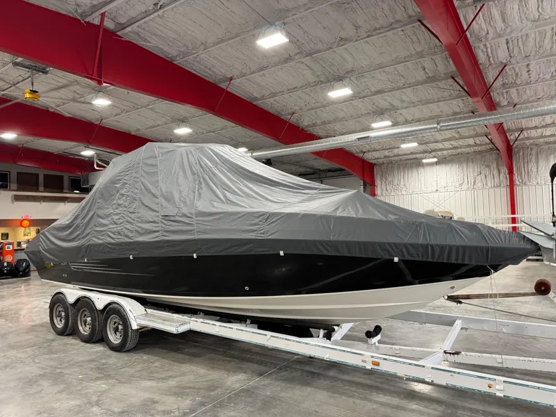 Slide: The Image of 2012 Larson LXi 288 boat covered on trailer in indoor storage facility. - 14