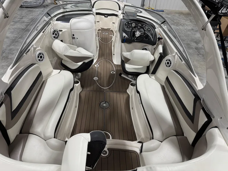 Slide: The Image of 2012 Larson LXi 288 boat interior with white seating and wood flooring. - 6