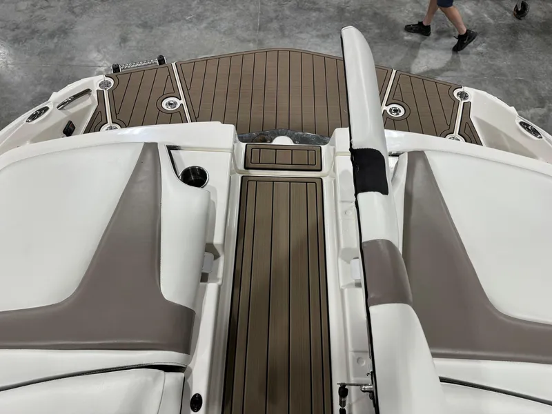 Slide: The Image of 2012 Larson LXi 288 boat interior with tan and white seating, wooden deck. - 7