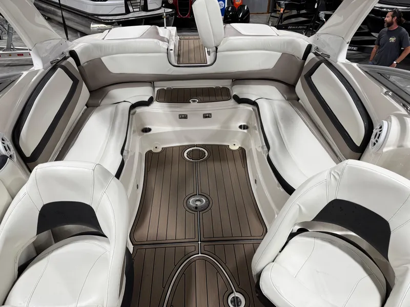 Slide: The Image of 2012 Larson LXi 288 boat interior with white seating and wood-style flooring. - 8