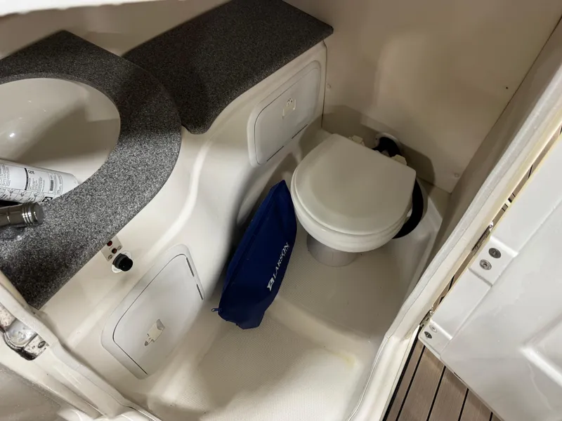 Slide: The Image of 2012 Larson LXi 288 boat bathroom with sink, toilet, and storage compartment. - 9