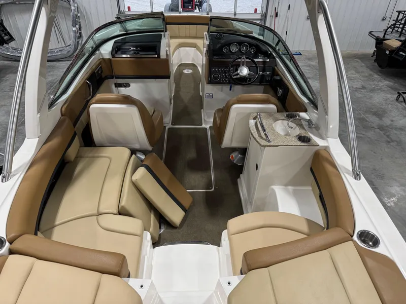 Slide: The Image of 2012 Sea Ray 250 SLX boat interior with beige seating and modern dashboard. - 6
