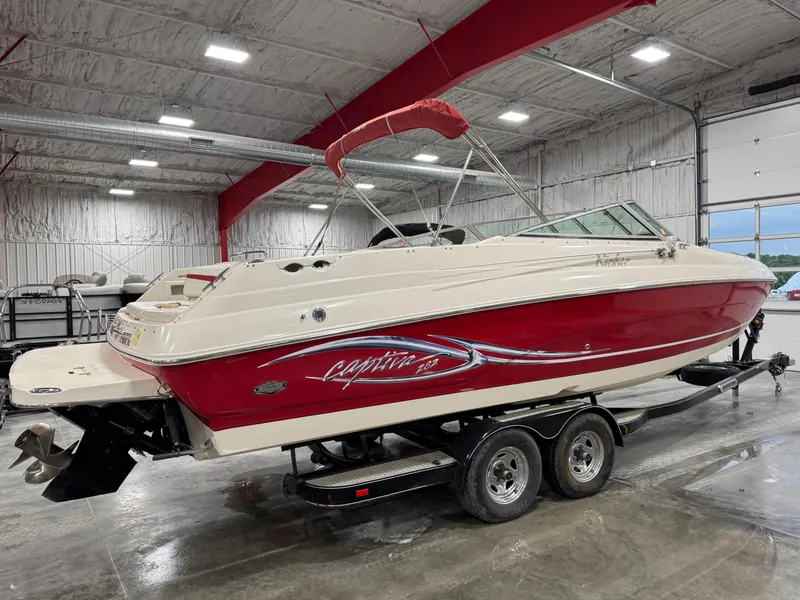 Slide: The Image of 2005 Rinker 282 BR boat with red and white design in a spacious indoor setting. - 4