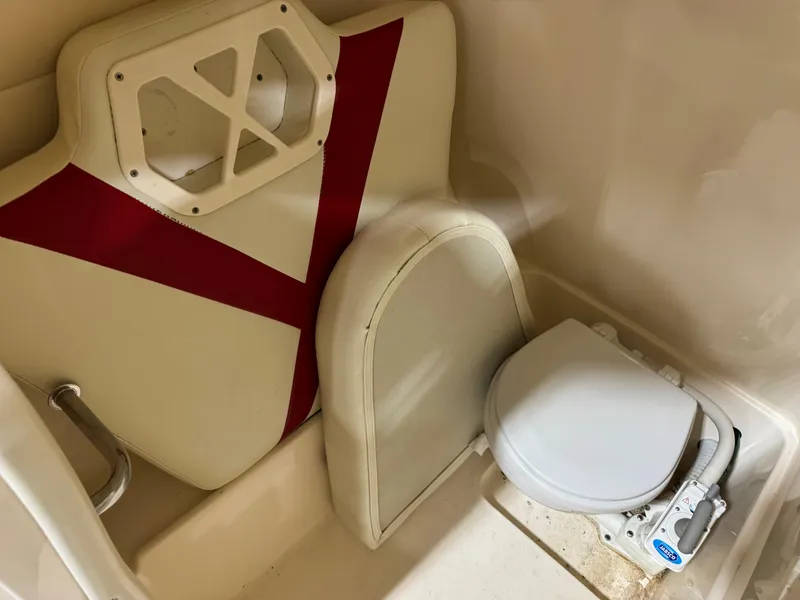 Slide: The Image of 2005 Rinker 282 BR boat interior with compact marine toilet and seat cushion. - 9