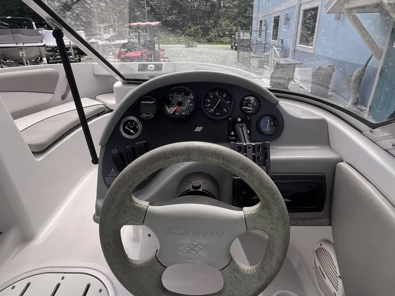 Slide: The Image of Steering wheel and dashboard of 2000 Four Winns 180 Horizon boat, featuring gauges and controls. - 7