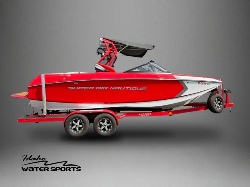 Slide: The Image of 2014 Correct Craft G23 Super Air Nautique boat on trailer, red and white design. - 1