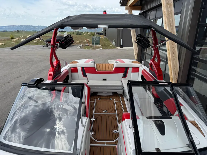 Slide: The Image of 2014 Correct Craft G23 boat with red and white interior, open cockpit, and black canopy. - 13