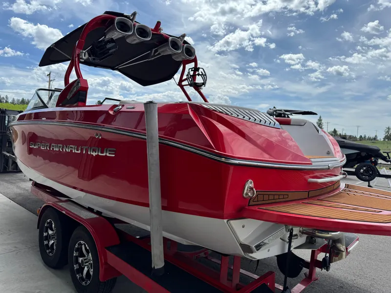 Slide: The Image of 2014 Correct Craft G23 boat in vibrant red on a trailer under a blue sky. - 5