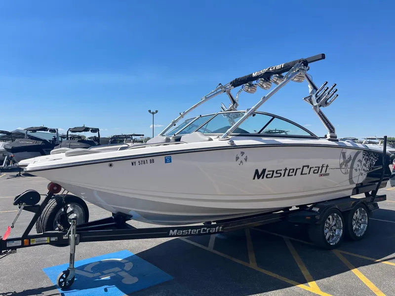 Slide: The Image of 2008 MasterCraft X35 boat on trailer in parking lot, clear sky background. - 10