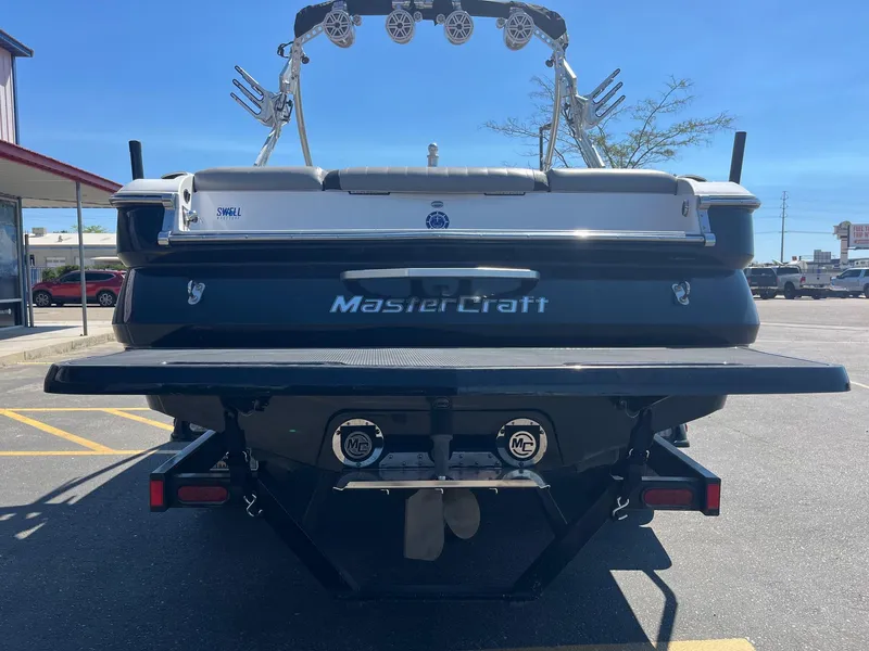 Slide: The Image of 2008 MasterCraft X35 boat rear view in parking lot, showcasing sleek design and branding. - 5