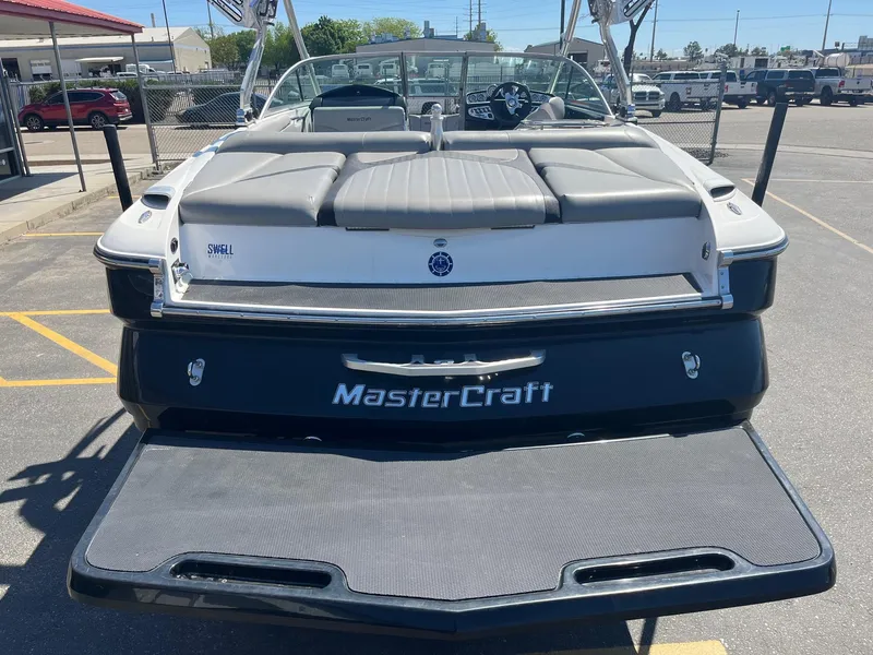 Slide: The Image of 2008 MasterCraft X35 boat, rear view, parked in a lot, showcasing swim platform. - 7