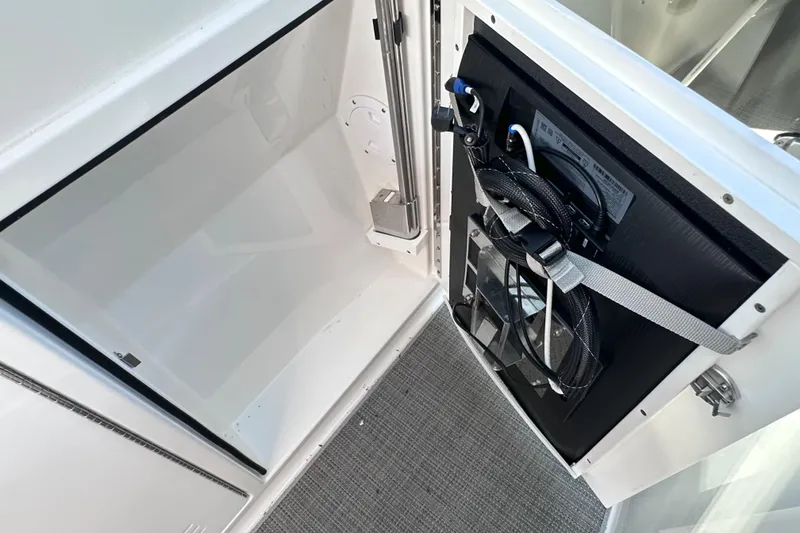 Slide: The Image of 2023 Formula 380 Super Sport Crossover OB storage compartment with secured cables and sleek design. - 23