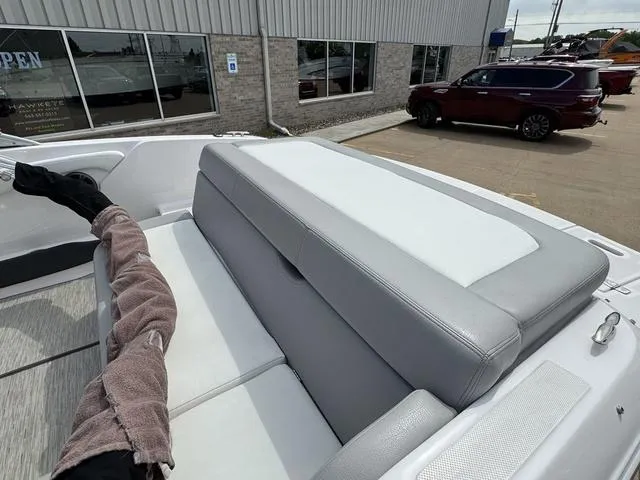Slide: The Image of 2019 Regal 1900 ES boat interior with gray and white seating, parked near a building. - 15