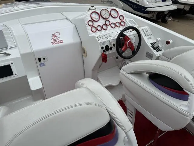 Slide: The Image of 2000 Baja 36 Outlaw boat cockpit with white leather seats and red-accented steering wheel. - 12