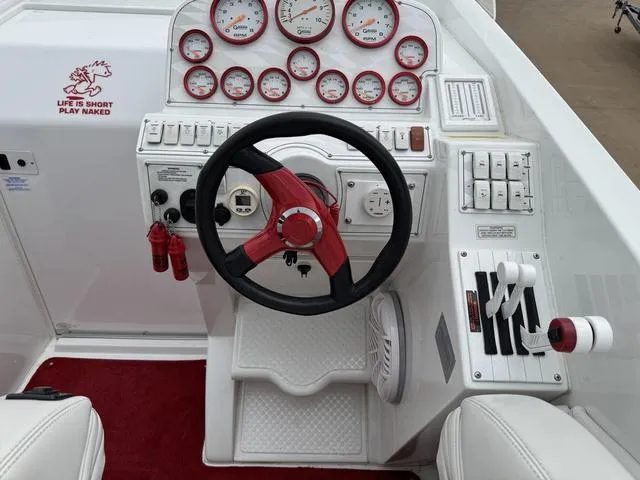Slide: The Image of 2000 Baja 36 Outlaw boat dashboard with red accents and multiple gauges. - 13