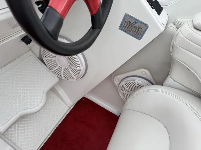 Slide: The Image of Interior of 2000 Baja 36 Outlaw boat with white seating and red steering wheel. - 18