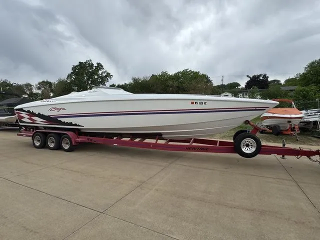 Slide: The Image of 2000 Baja 36 Outlaw speedboat on a red trailer, parked outdoors. - 3