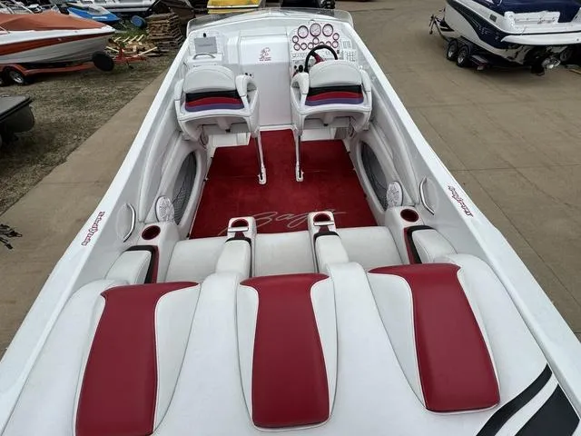 Slide: The Image of 2000 Baja 36 Outlaw boat interior with red and white seating, dual helm chairs, and dashboard. - 7