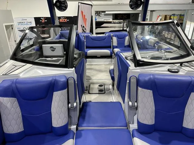 Slide: The Image of 2021 Malibu M220 boat interior with blue and white seating, modern design. - 15