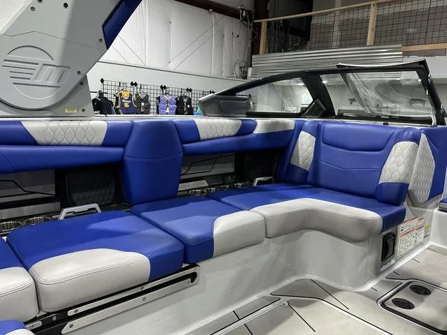 Slide: The Image of 2021 Malibu M220 boat interior with blue and white seating, modern design. - 8