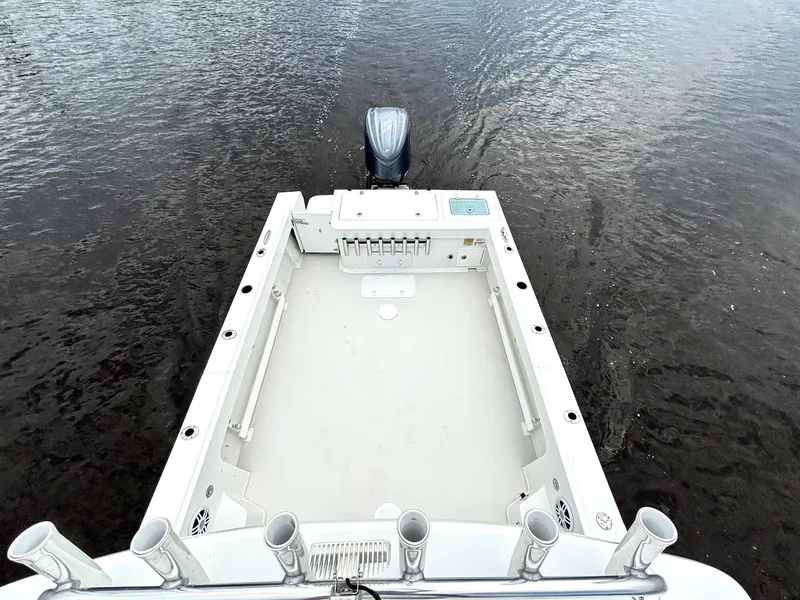 Slide: The Image of 2022 Parker 2320 Sport Cabin boat with spacious deck and outboard motor on water. - 10