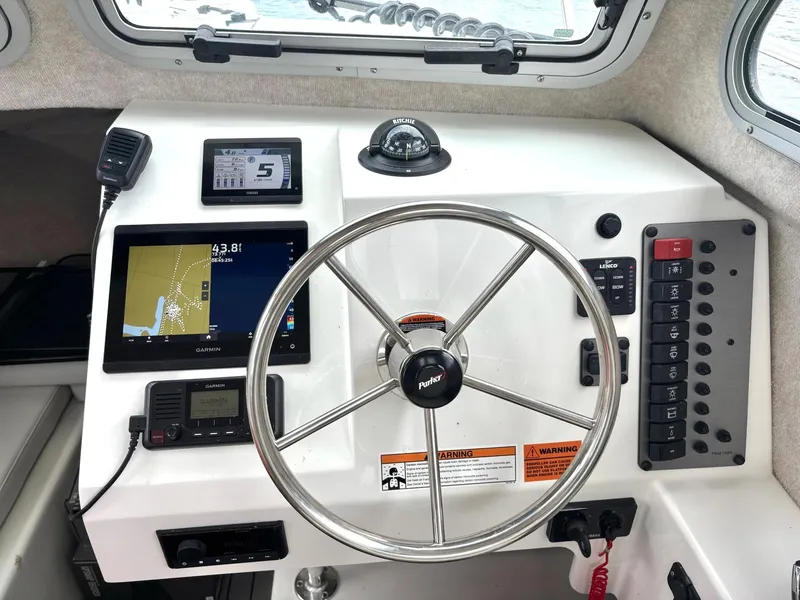 Slide: The Image of 2022 Parker 2320 Sport Cabin dashboard with steering wheel, navigation, and control panels. - 12