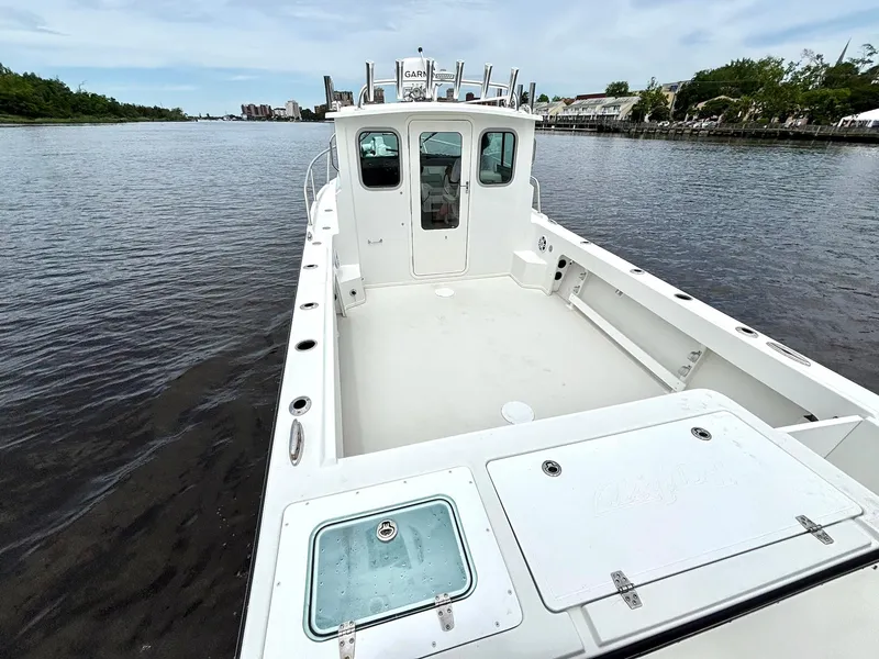 Slide: The Image of 2022 Parker 2320 Sport Cabin boat on calm water, showcasing spacious deck and cabin. - 15