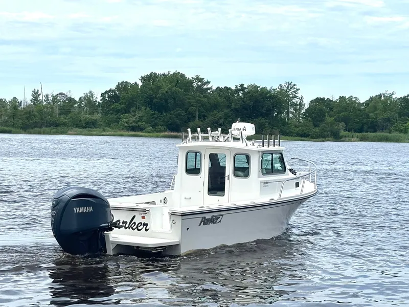 Slide: The Image of 2022 Parker 2320 Sport Cabin boat on a calm lake with Yamaha engine. - 5