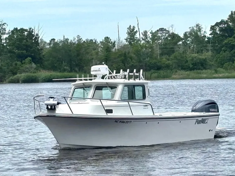 Slide: The Image of 2022 Parker 2320 Sport Cabin boat cruising on a calm river. - 7