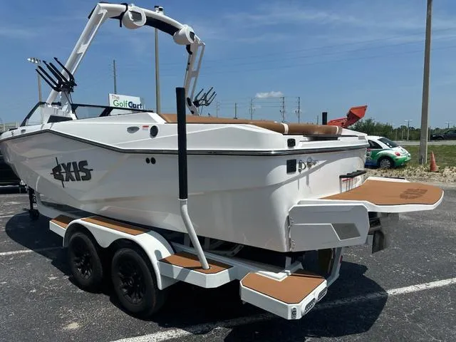 Slide: The Image of 2025 Axis Wake Research T Series T220 boat on trailer, parked outdoors. - 5