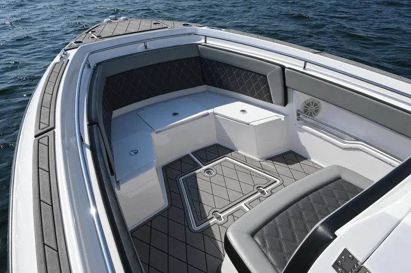 Slide: The Image of 2022 Drakkar 280 CC boat interior with cushioned seating and sleek design on the water. - 16