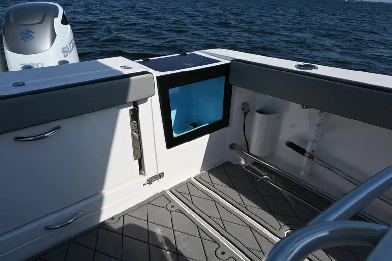 Slide: The Image of 2022 Drakkar 280 CC boat interior with storage compartments and Suzuki engine on water. - 45