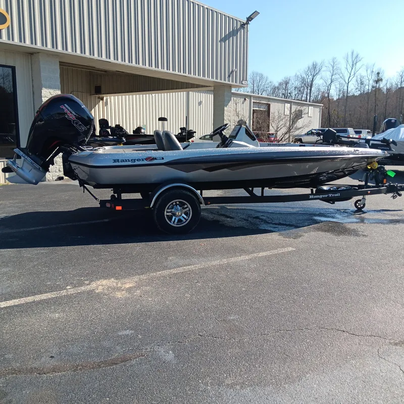 Slide: The Image of 2025 Ranger Z185 boat on trailer outside a warehouse, side view. - 3