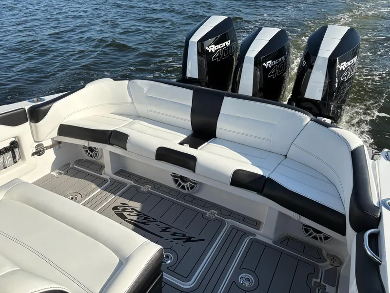Slide: The Image of 2025 Nor-Tech 340 Sport boat with triple outboard engines, white and black seating, on the water. - 15