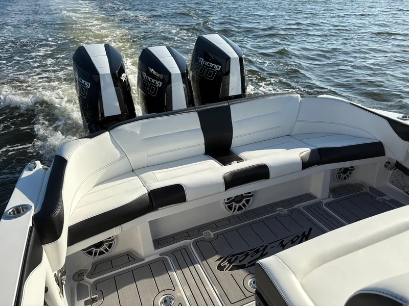 Slide: The Image of 2025 Nor-Tech 340 Sport boat with triple engines, white and black seating, on open water. - 17