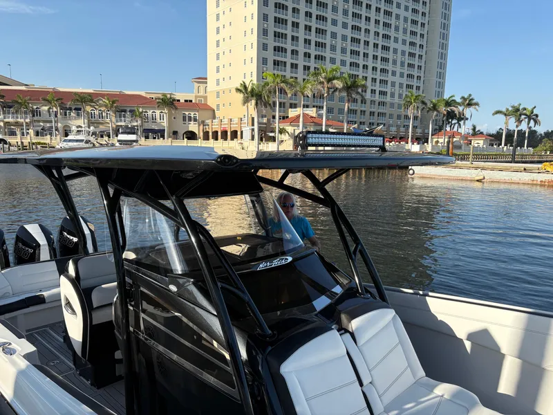 Slide: The Image of 2025 Nor-Tech 340 Sport boat docked near waterfront buildings and palm trees. - 6