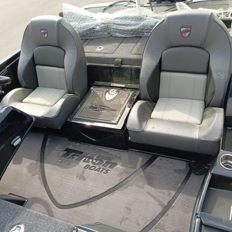 Slide: The Image of 2025 Triton 20XP Patriot boat interior with dual gray seats and branded flooring. - 10