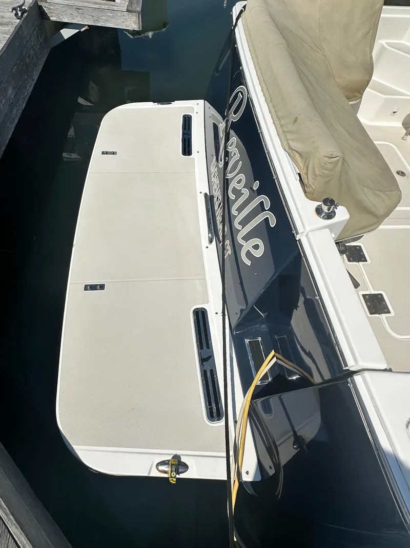 Slide: The Image of 2013 Back Cove 34 boat docked with swim platform and covered seating area. - 11
