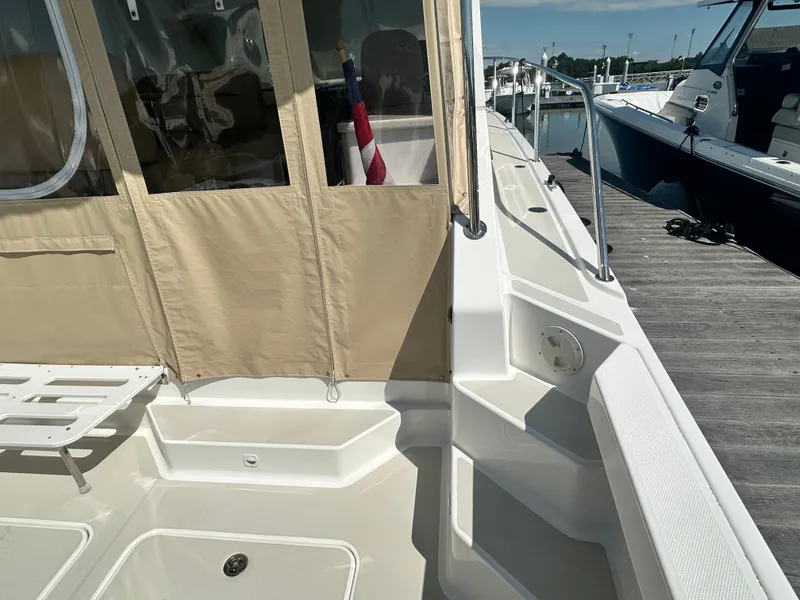 Slide: The Image of 2013 Back Cove 34 boat deck with beige canopy and docked at marina. - 12